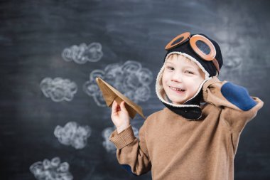 bir kağıt uçak pilot şapkalı çocuk çalış