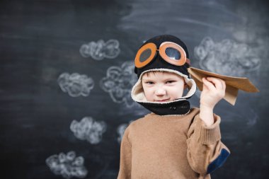 bir kağıt uçak pilot şapkalı çocuk çalış