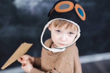 bir kağıt uçak pilot şapkalı çocuk çalış