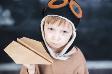 bir kağıt uçak pilot şapkalı çocuk çalış