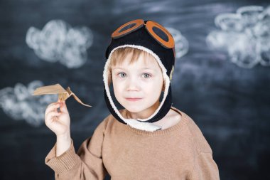 bir kağıt uçak pilot şapkalı çocuk çalış