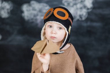 bir kağıt uçak pilot şapkalı çocuk çalış