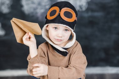 bir kağıt uçak pilot şapkalı çocuk çalış
