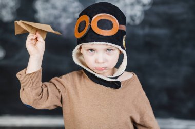 bir kağıt uçak pilot şapkalı çocuk çalış