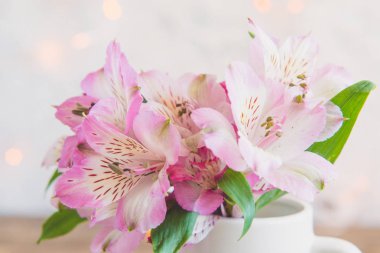 Beyaz bir bardağa bir buket çiçek standları