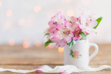 Beyaz bir kurdele ile beyaz bir kupa buket sevimli