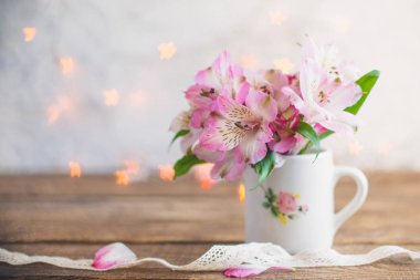 buket çiçek beyaz bir kurdele ile beyaz bir kupa