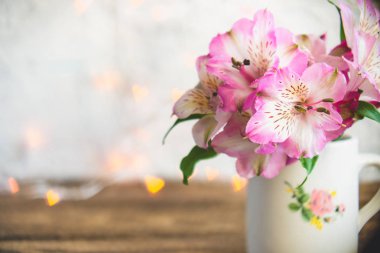 Beyaz bir bardağa küçük bir buket çiçek standları