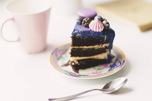 Кусочек праздничного лилового торта с ягодами на тарелке — стоковое фото