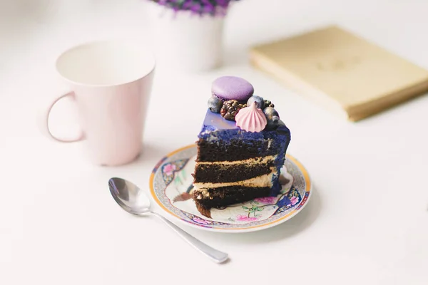 Un morceau de gâteau lilas festif avec des baies sur une assiette — Photo