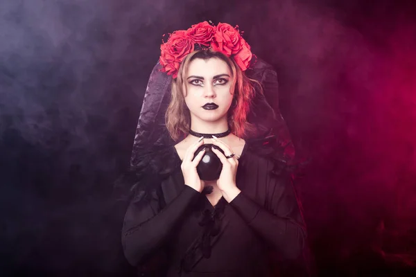 Bruxa menina em uma grinalda de rosas vermelhas — Fotografia de Stock