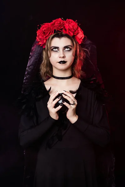 Κορίτσι μάγισσα σε ένα στεφάνι από κόκκινα τριαντάφυλλα — Φωτογραφία Αρχείου