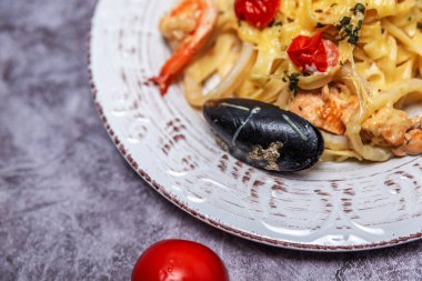 Beyaz tabakta deniz mahsullü erişte.