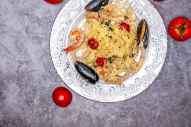 Beyaz tabakta deniz mahsullü erişte.