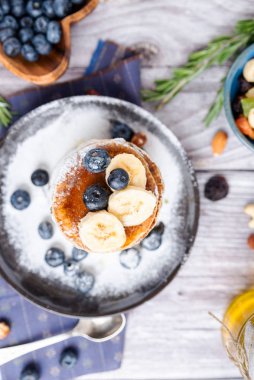 Kır kahvaltısı krepleri siyah bir tabakta yaban mersini ve bal ile