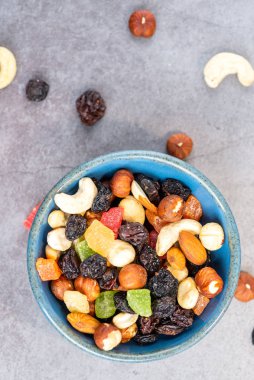 Vejetaryen atıştırmalığı sağlıklı yiyecek fındık ve tabakta kuru meyve.