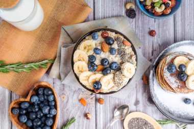 Bir tabakta yaban mersinli pankek muzlu ve fındıklı yulaf ezmesi 