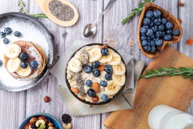 Bir tabakta yaban mersinli pankek muzlu ve fındıklı yulaf ezmesi 