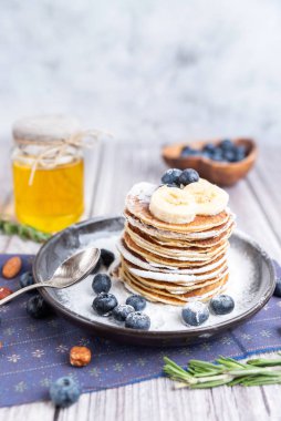 Kır kahvaltısı krepleri siyah bir tabakta yaban mersini ve bal ile