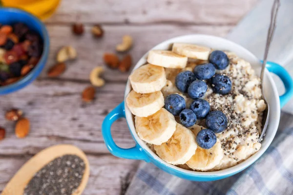 oatmeal with banana and blueberries in a blue bowl