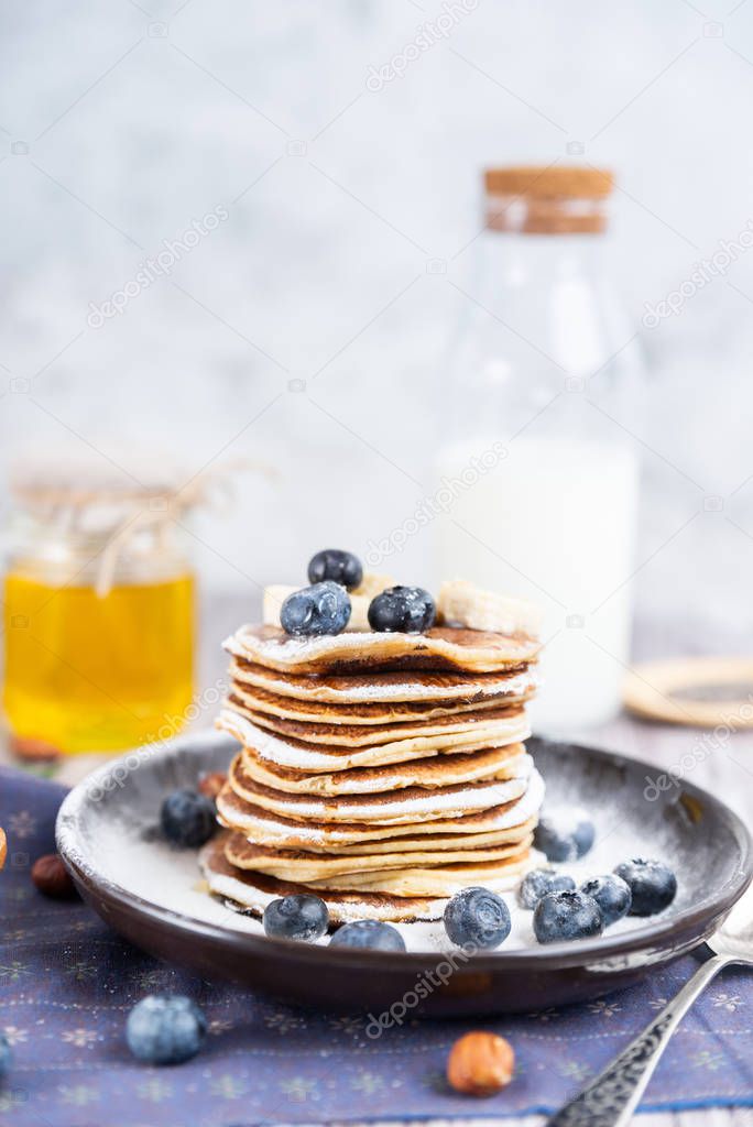 pancakes on a plate with blueberries and milk