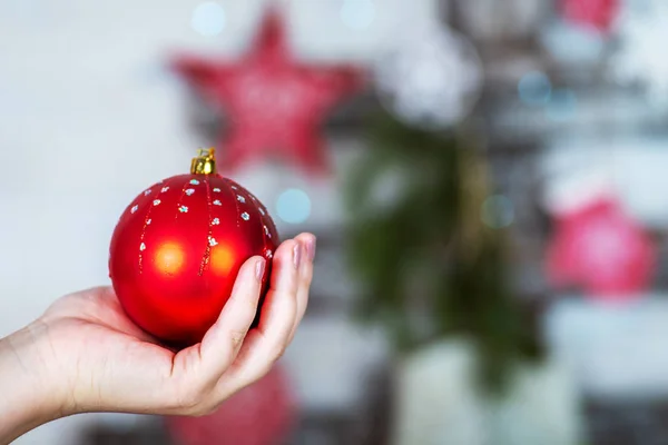 Kırmızı Noel topunu tutan el.