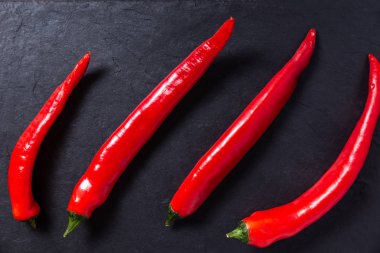 Kırmızı biberler siyah doğrama tahtasında