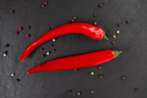 Red chili peppers on a black chopping Board — Stock Photo, Image