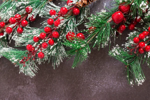 Рождественские елки с красными ягодами и снежинками на тёмном фоне — стоковое фото