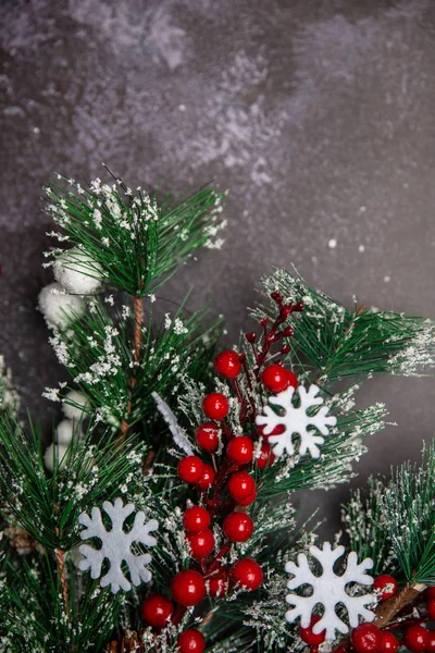 Christmas fir twigs with red berries and snowflakes on dark background Royalty Free Stock Photos