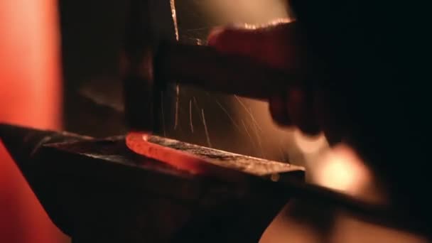 Smith κτυπά το σφυρί σε ένα μεταλλικό κομμάτι προς κατεργασία — Αρχείο Βίντεο