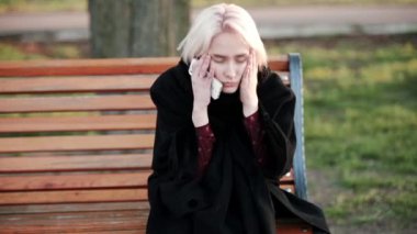 Sarışın kadın gerçekleştirip çerçeve dışında bir tezgah deneyimleri stres bir baş ağrısı Sad memnun oturur.
