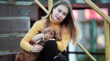Sarışın ve köpek yavru horoz İspanyol o vuruş, dokunuşlar kucak öpücükler sevinir akşam şehrin gülümsüyor