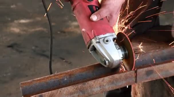 Man klipper en rostig metall beam, med hjälp av en cirkulär turbin. Vinkelslip slowmotion färdiga arbetet ljud — Stockvideo