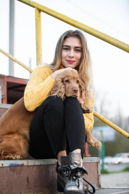 Jennifer Aniston ile Cocker Spaniel köpek bir metal merdiven üzerinde oturan benzeyen güzel sarışın