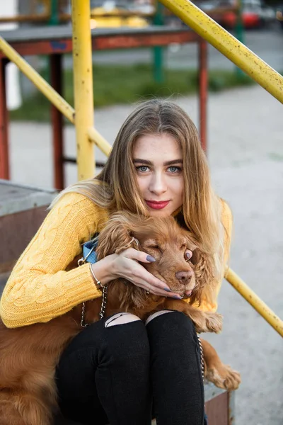 Jennifer Aniston ile Cocker Spaniel köpek bir metal merdiven üzerinde oturan benzeyen güzel sarışın