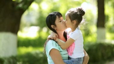Orta yaşlı bir kadın hugs ve onu kucağında tutmak kızı öper. Açık