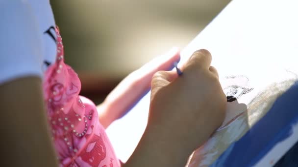 Little girl child sits in the park, on a bench and ricott oil on canvas close-up — Stock Video