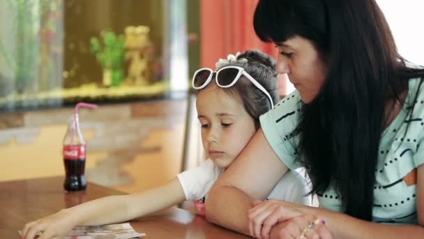 Mała dziewczynka dziecko brunetka latina siedząc w kawiarni, z matką, smutny, marzy — Wideo stockowe