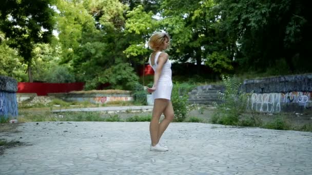 Junge asiatische Frau tanzt moderne Choreographie im Stadtpark, draußen. Ruinen der Stadt und Graffiti-Hip-Hop — Stockvideo