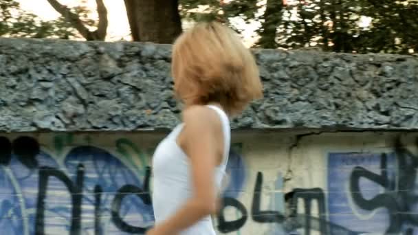 Junge asiatische Frau tanzt moderne Choreographie im Stadtpark vor den Ruinen der Stadt und Graffiti-Vielfalt — Stockvideo