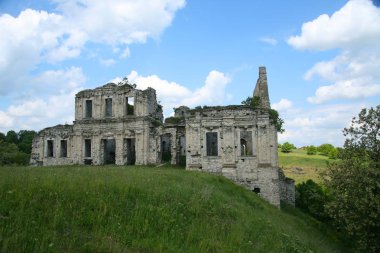 Açık gün beyaz bulutlar terk edilmiş bir binada taştan yapılmış bir bozkır vadinin ortasında duruyor.