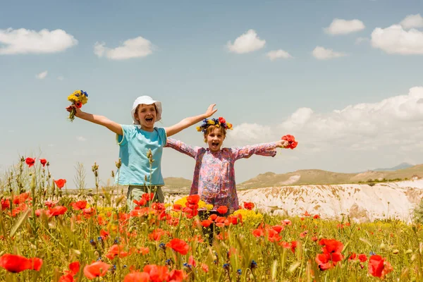 Duas meninas felizes no campo de papoula ao ar livre — Fotografia de Stock