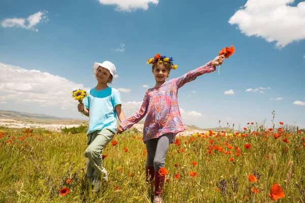 Duas meninas felizes no campo de papoula ao ar livre — Fotografia de Stock