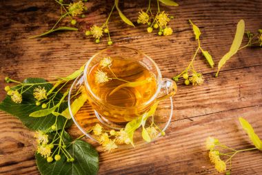 Fincan çay ve ıhlamur ahşap arka plan üzerinde