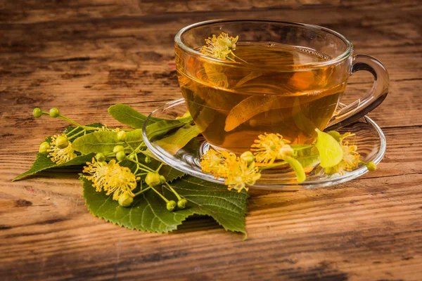 Tasse Tee und Linde auf Holzgrund — Stockfoto