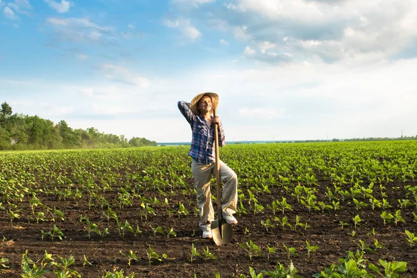 Happy small farmer with spade in spring field — Stock Photo, Image