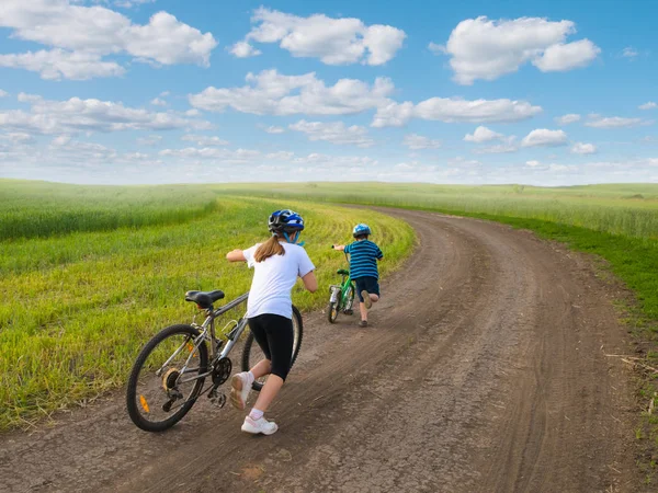 Bambini sportivi che camminano in salita con biciclette — Foto Stock