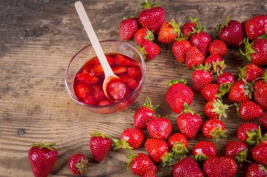 Taze kırmızı çilek ve reçel ahşap arka plan üzerinde