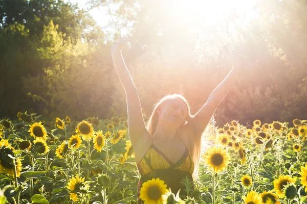 Beauty sunlit woman on yellow sunflower field Freedom and happiness concept — Stock Photo, Image